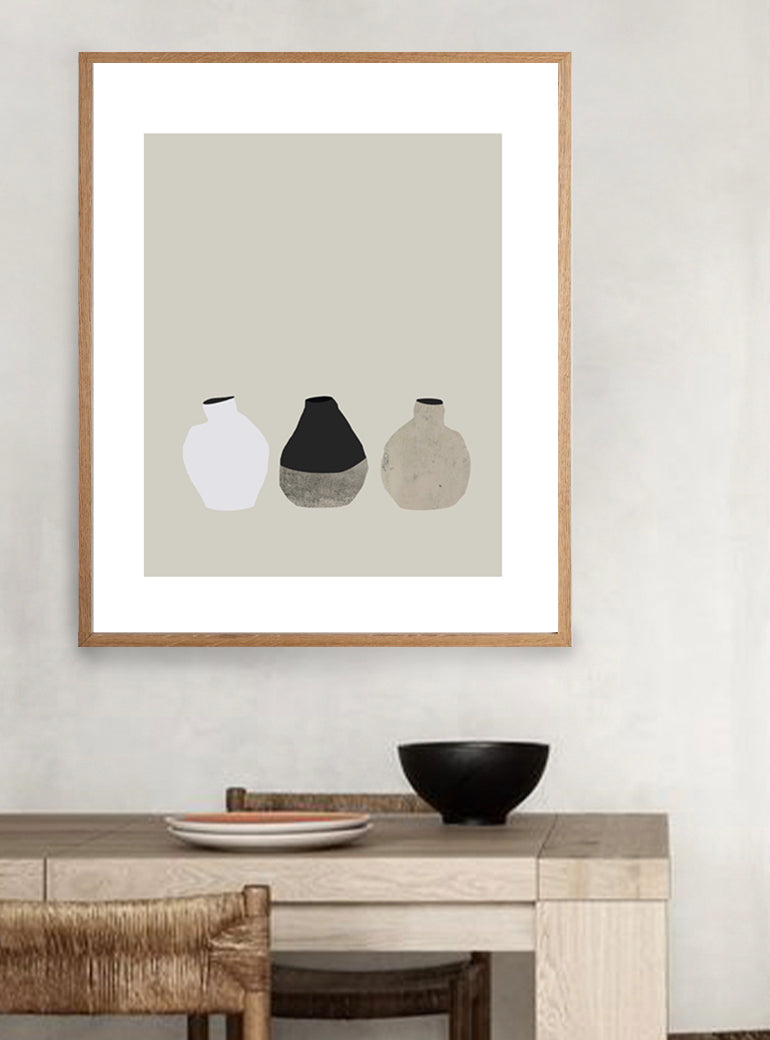A 3 Little Vases Print featuring a trio of abstract vases in a neutral palette, elegantly framed in oak and printed on premium archival paper, ready to complement a modern interior by The Print Supply.