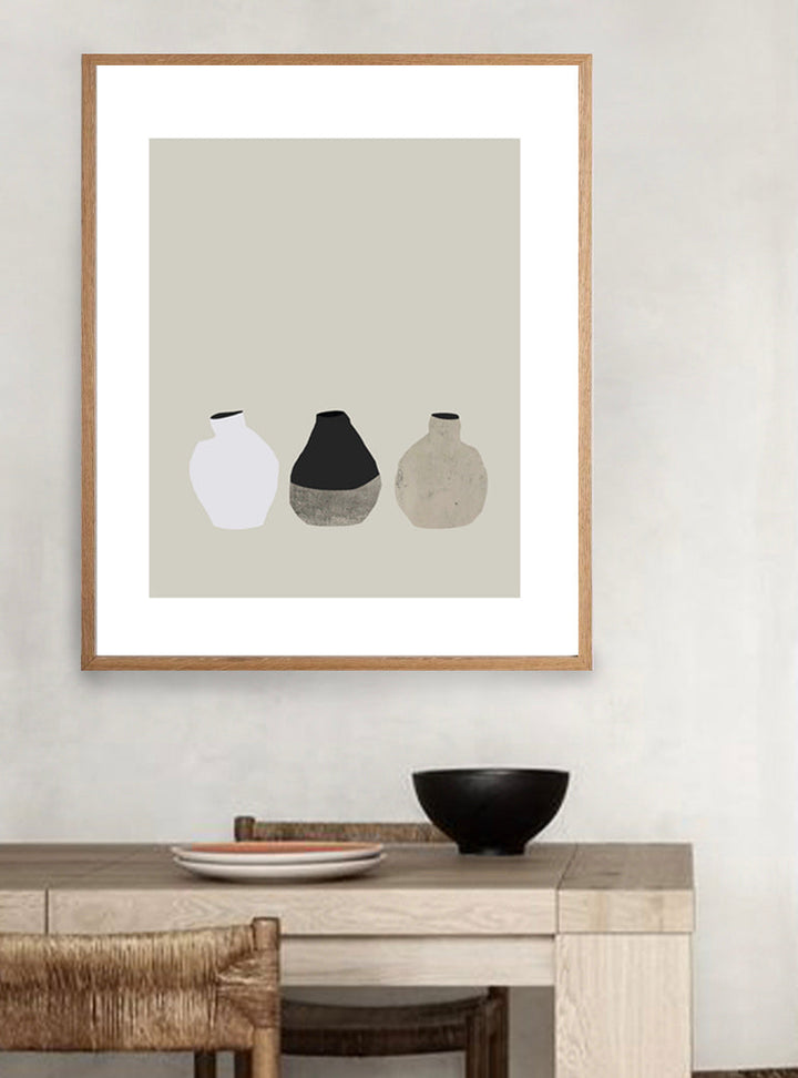 A 3 Little Vases Print featuring a trio of abstract vases in a neutral palette, elegantly framed in oak and printed on premium archival paper, ready to complement a modern interior by The Print Supply.