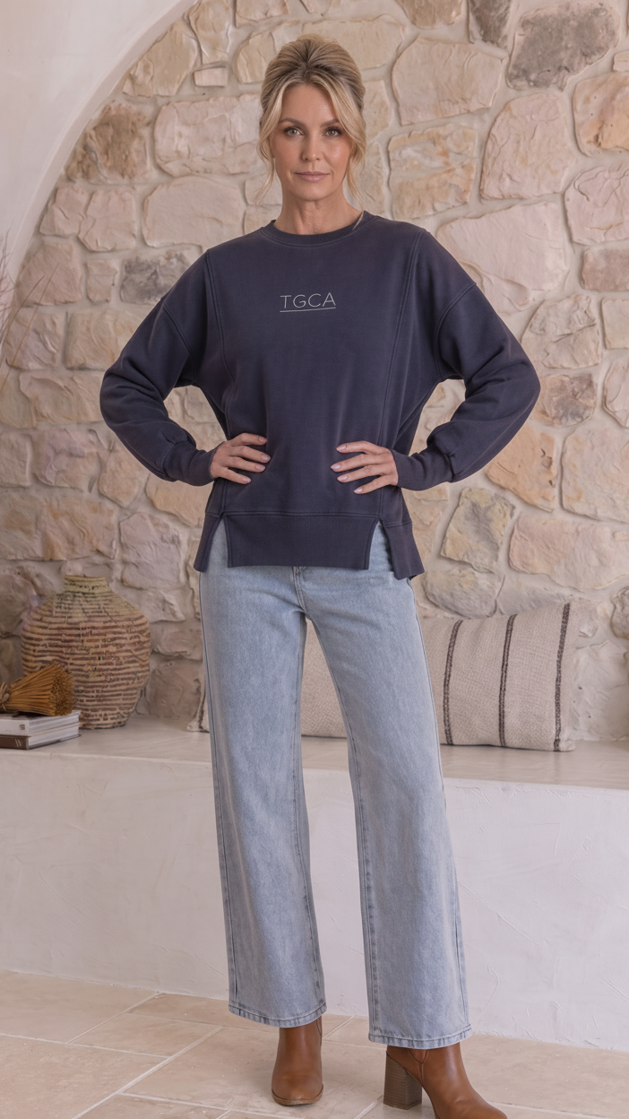 A woman modeling a dark navy blue crewneck sweatshirt with &
