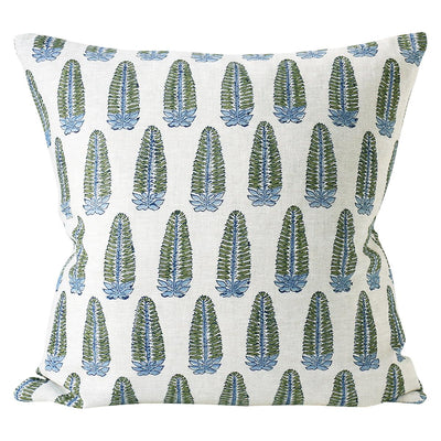 A white Akola Moss Cushion crafted from Indian textiles, featuring a hand block printed pattern of green cypress trees and blue flowers by Walter G.